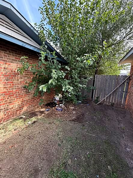 Bush trimming along a brick house